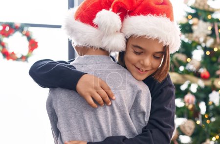 Photo for Adorable boys hugging each other celebrating christmas at home - Royalty Free Image