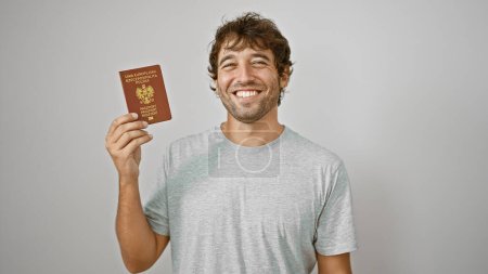 Foto de Joven feliz, radiante de alegría, orgullosamente sostiene su pasaporte polaco sobre un fondo blanco aislado - Imagen libre de derechos