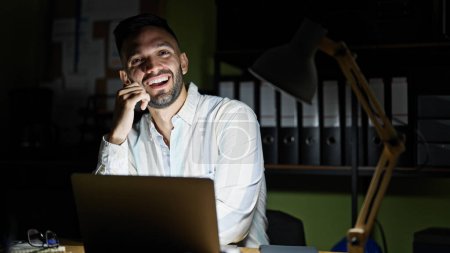 Photo for Young hispanic man business worker using laptop smiling at the office - Royalty Free Image