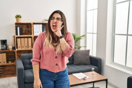 Photo for Young hispanic woman working at the office wearing glasses clueless and confused with open arms, no idea and doubtful face. - Royalty Free Image