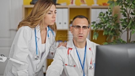 Téléchargez les photos : Médecins hommes et femmes regardant l'ordinateur ensemble parlant à la clinique - en image libre de droit