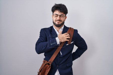 Photo for Hispanic man with beard wearing business clothes suffering of neck ache injury, touching neck with hand, muscular pain - Royalty Free Image