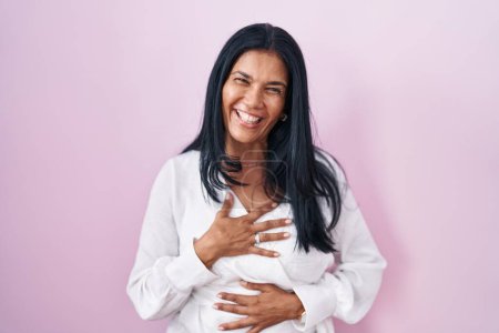 Photo for Mature hispanic woman standing over pink background smiling and laughing hard out loud because funny crazy joke with hands on body. - Royalty Free Image