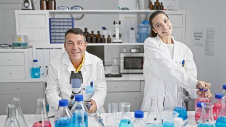 Photo for Man and woman scientists cheerfully working together in a high-tech laboratory - Royalty Free Image