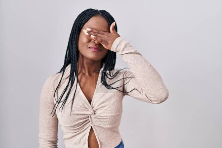 Photo for African woman with braids standing over white background covering eyes with hand, looking serious and sad. sightless, hiding and rejection concept - Royalty Free Image
