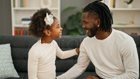 Photo for African american father and daughter sitting on sofa speaking at home - Royalty Free Image