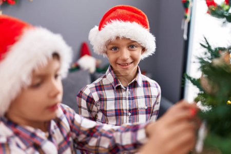 Photo for Adorable boys smiling confident decorating christmas tree at home - Royalty Free Image