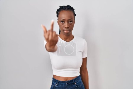 Foto de Beautiful black woman standing over isolated background showing middle finger, impolite and rude fuck off expression - Imagen libre de derechos