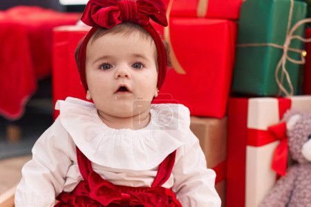 Téléchargez les photos : Adorable bambin blonde assis sur le sol par des cadeaux de Noël à la maison - en image libre de droit
