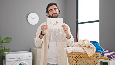 Photo for Young hispanic man asking for help at laundry room - Royalty Free Image