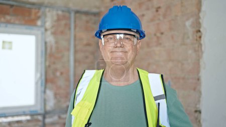 Photo for Middle age grey-haired man builder smiling confident standing at construction site - Royalty Free Image