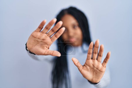 Photo for African american woman standing over blue background doing frame using hands palms and fingers, camera perspective - Royalty Free Image