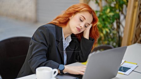 Téléchargez les photos : Jeune rousse femme d'affaires travailleur fatigué travailler regarder à la terrasse du café - en image libre de droit