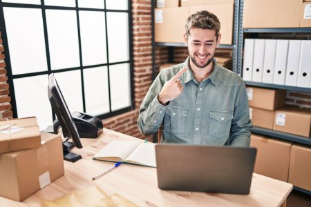 Téléchargez les photos : Homme hispanique avec barbe travaillant dans une petite entreprise commerce électronique souriant heureux pointant avec la main et le doigt - en image libre de droit