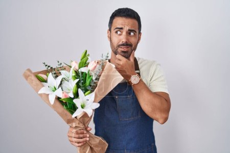 Photo for Hispanic man with beard working as florist thinking worried about a question, concerned and nervous with hand on chin - Royalty Free Image