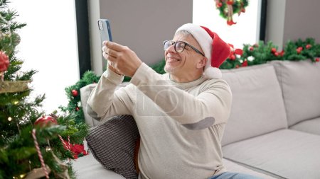 Foto de Hombre de pelo gris de mediana edad hacer foto al árbol de Navidad en casa - Imagen libre de derechos