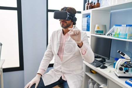 Foto de Middle age man scientist using virtual reality glasses at laboratory - Imagen libre de derechos