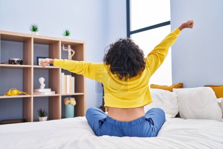 Photo for Young beautiful hispanic woman waking up stretching arms at bedroom - Royalty Free Image