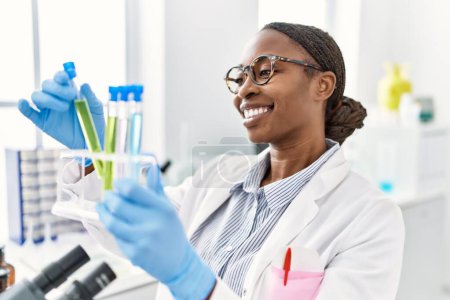 Photo for African american woman scientist holding test tubes at laboratory - Royalty Free Image