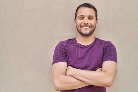 Foto de Young man smiling confident standing with arms crossed gesture over white isolated background - Imagen libre de derechos
