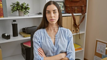 Photo for Young beautiful hispanic woman business worker sitting with serious face and arms crossed gesture at the office - Royalty Free Image