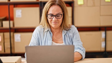 Photo for Middle age hispanic woman ecommerce business worker using laptop at office - Royalty Free Image