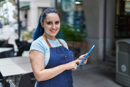 Foto de Young caucasian woman waitress smiling confident using touchpad at coffee shop terrace - Imagen libre de derechos