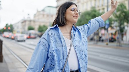 Téléchargez les photos : Jeune belle femme hispanique appelant au taxi avec la main levée dans les rues de Vienne - en image libre de droit