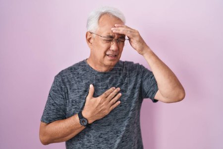 Photo for Middle age man with grey hair standing over pink background touching forehead for illness and fever, flu and cold, virus sick - Royalty Free Image