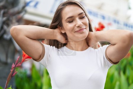 Téléchargez les photos : Young caucasian woman smiling confident relaxed with hands on head at park - en image libre de droit