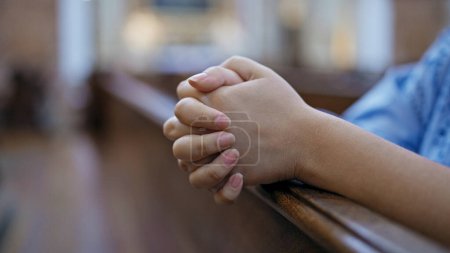 Téléchargez les photos : Jeune belle femme hispanique priant sur un banc d'église à l'église Saint-Karl Borromus - en image libre de droit