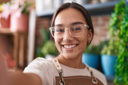 Photo for Young beautiful hispanic woman florist smiling confident make selfie by camera at florist - Royalty Free Image