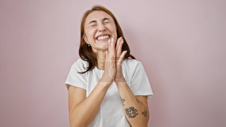 Foto de Mujer joven sonriendo confiado aplaudiendo las manos sobre el fondo rosa aislado - Imagen libre de derechos