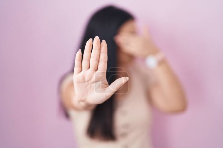 Photo for Young hispanic woman standing over pink background covering eyes with hands and doing stop gesture with sad and fear expression. embarrassed and negative concept. - Royalty Free Image