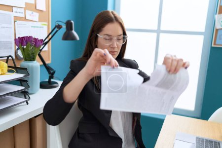 Foto de Joven hermosa mujer trabajadora de negocios rompiendo documento en la oficina - Imagen libre de derechos