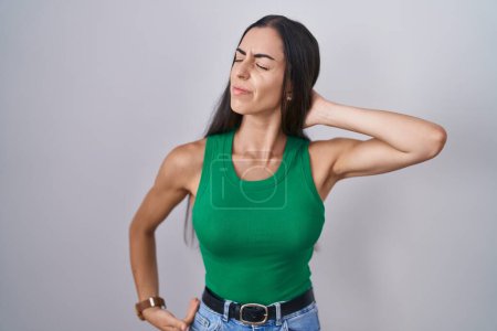 Photo for Young woman standing over isolated background suffering of neck ache injury, touching neck with hand, muscular pain - Royalty Free Image