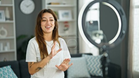 Foto de Joven hermosa mujer hispana sonriendo confidente grabación tutorial hablando en casa - Imagen libre de derechos