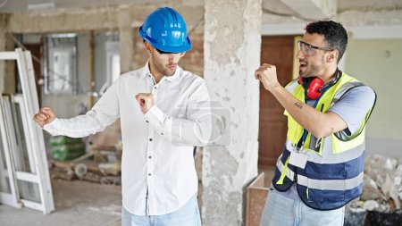 Photo for Two men builder and architect smiling confident dancing at construction site - Royalty Free Image