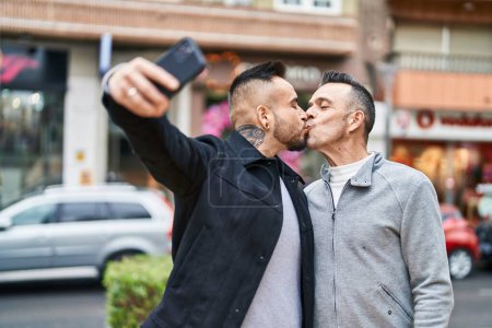 Téléchargez les photos : Deux hommes couple faire selfie par smartphone baisers à la rue - en image libre de droit