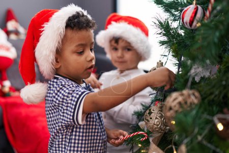 Téléchargez les photos : Adorables garçons décorant arbre de Noël à la maison - en image libre de droit