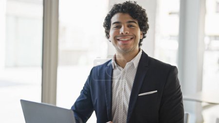 Photo for Young latin man business worker using laptop smiling at office - Royalty Free Image