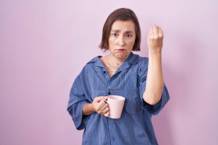 Foto de Mujer hispana de mediana edad bebiendo una taza de café haciendo un gesto italiano con la mano y los dedos expresión de confianza - Imagen libre de derechos