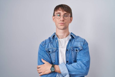 Photo for Caucasian blond man standing wearing glasses skeptic and nervous, disapproving expression on face with crossed arms. negative person. - Royalty Free Image