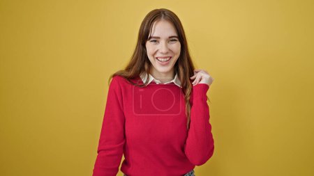 Téléchargez les photos : Jeune femme hispanique souriante danse confiante sur fond jaune isolé - en image libre de droit