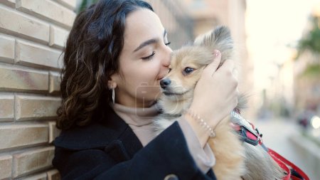 Téléchargez les photos : Jeune femme hispanique avec chien debout baisers dans la rue - en image libre de droit