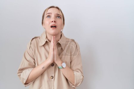 Photo for Young caucasian woman wearing casual shirt begging and praying with hands together with hope expression on face very emotional and worried. begging. - Royalty Free Image