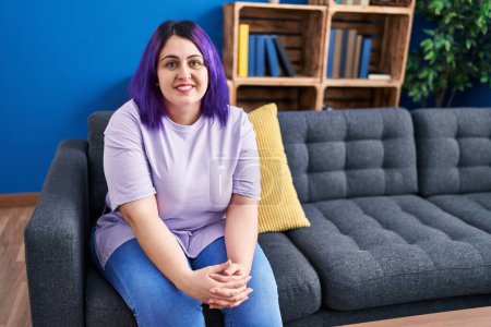 Photo for Young beautiful plus size woman smiling confident sitting on sofa at home - Royalty Free Image
