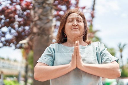 Téléchargez les photos : Senior woman doing yoga exercise at park - en image libre de droit