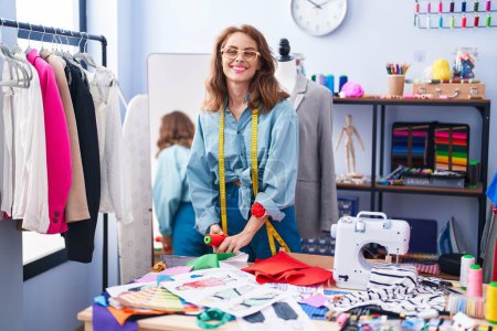 Téléchargez les photos : Jeune belle femme hispanique tailleur souriant confiance debout au magasin de tailleur - en image libre de droit