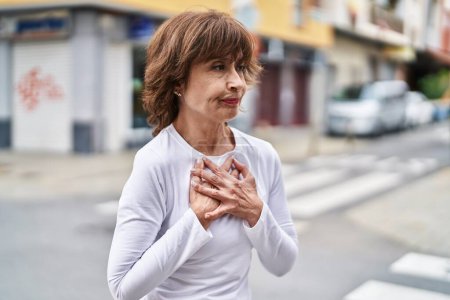 Foto de Middle age woman coughing at street - Imagen libre de derechos